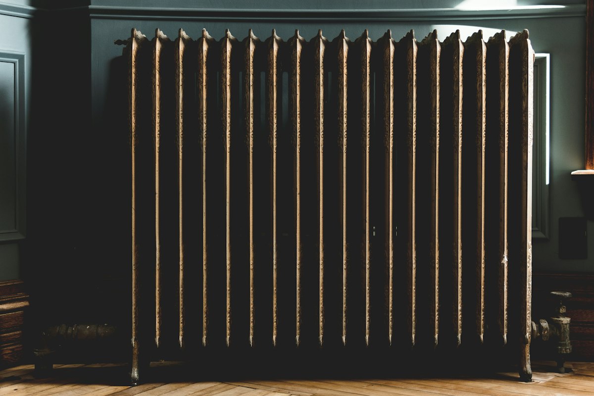 A tall column radiator in a dark, moody room