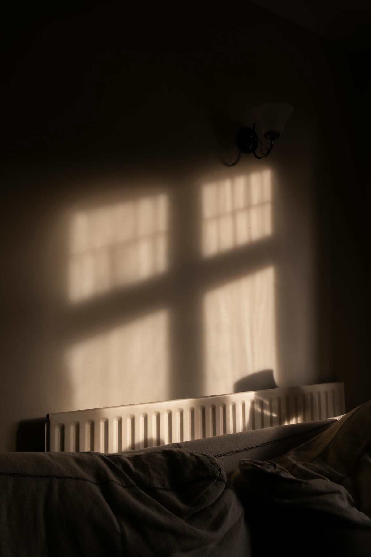 Evening light from a window falling on a radiator in a dark room