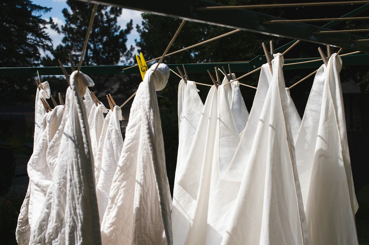 White sheets and cloths pegged up to dry on a rack