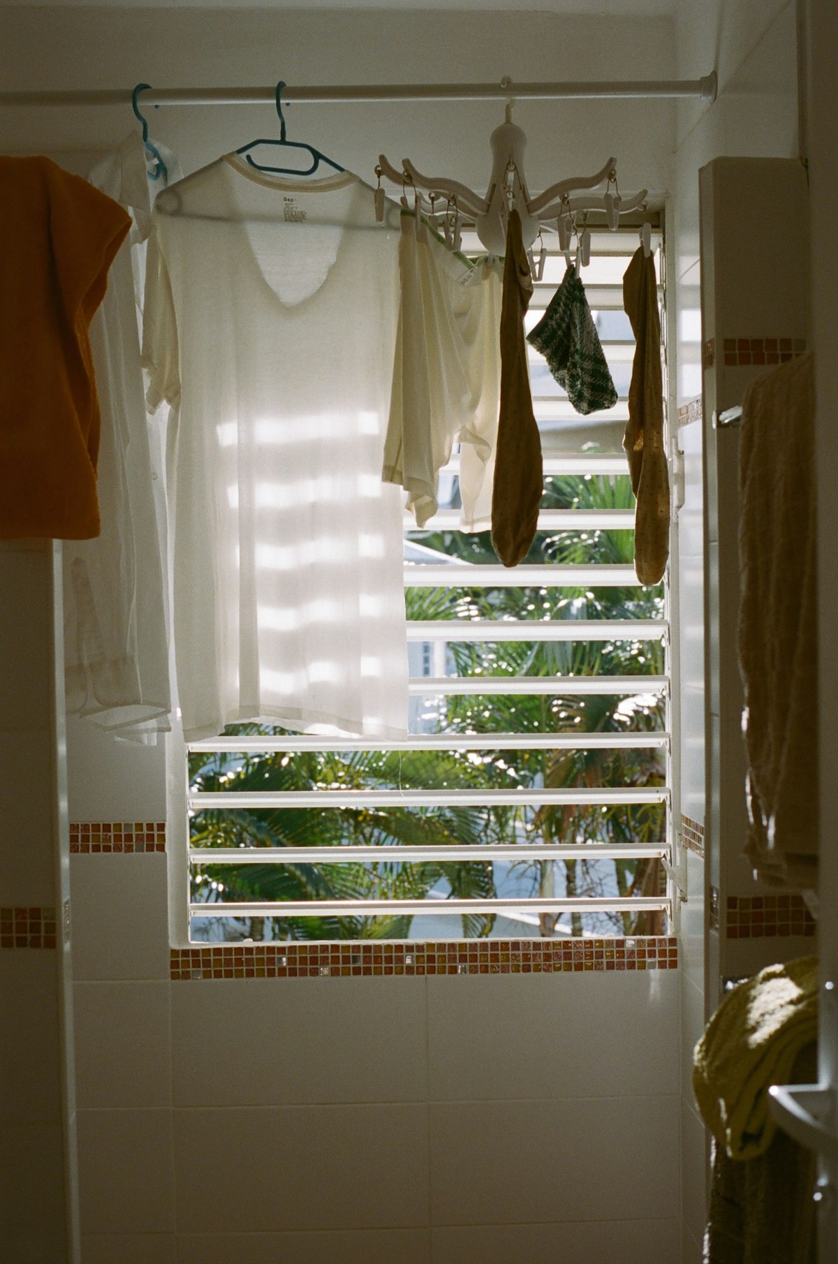 Washing hanging to dry beside an open window with shutters
