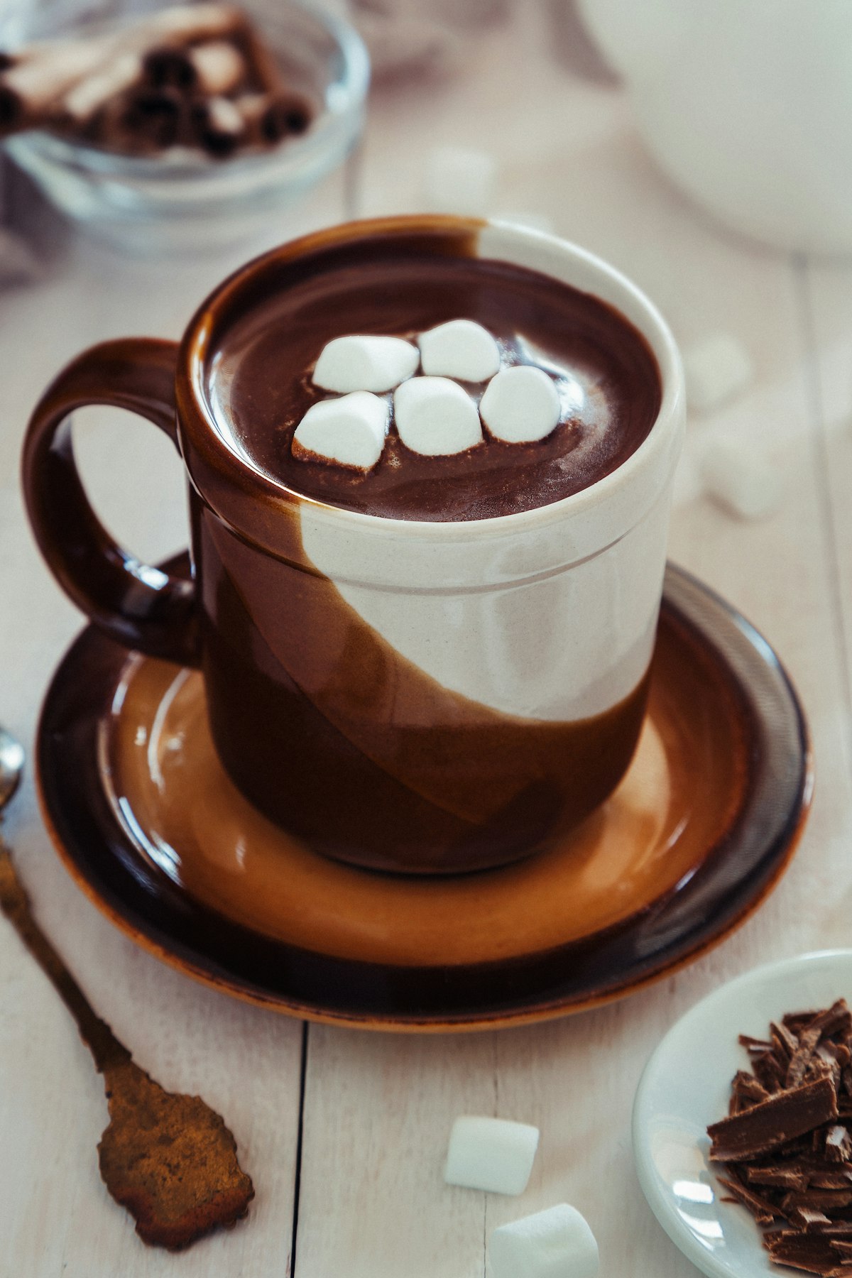 A mug of hot chocolate with marshmallows on a saucer