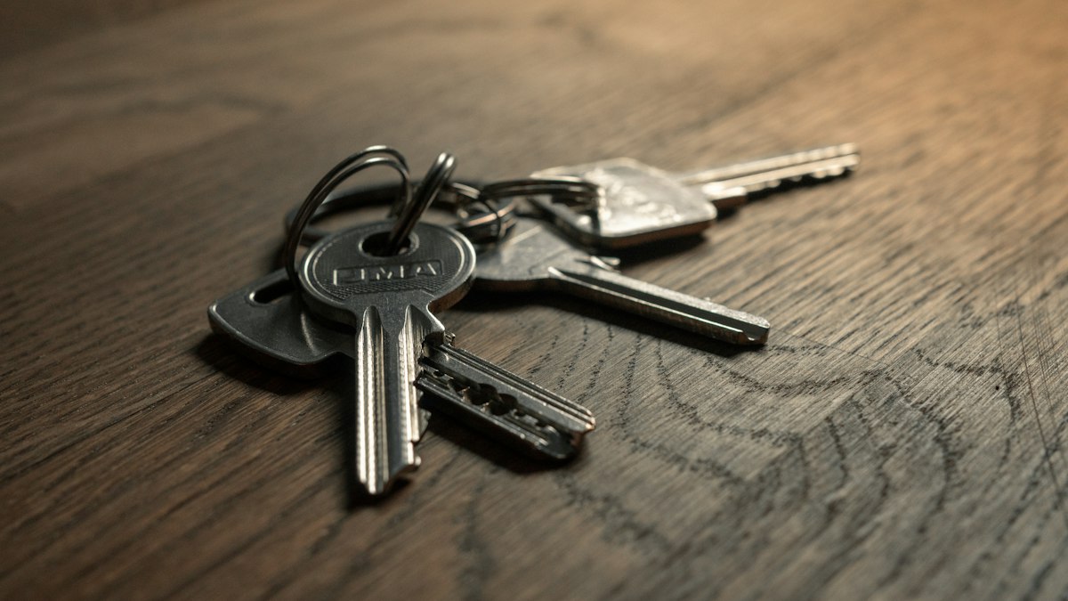 A bunch of house keys lying on a wooden table