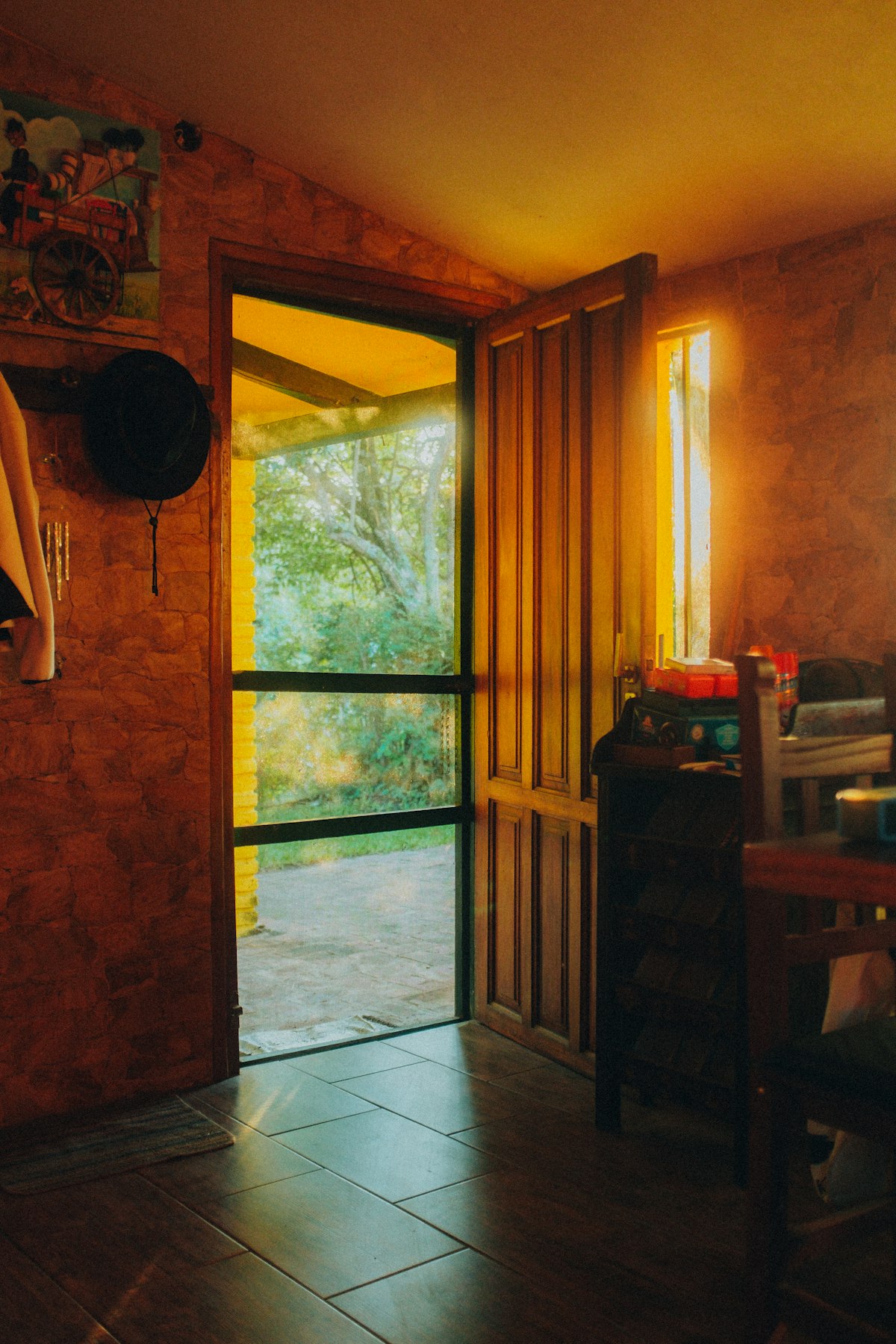 A warm-toned room with a tall glazed door open to a garden