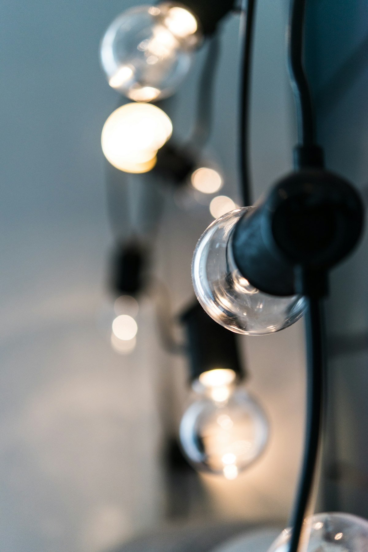 Warm festoon light bulbs glowing against a dark background