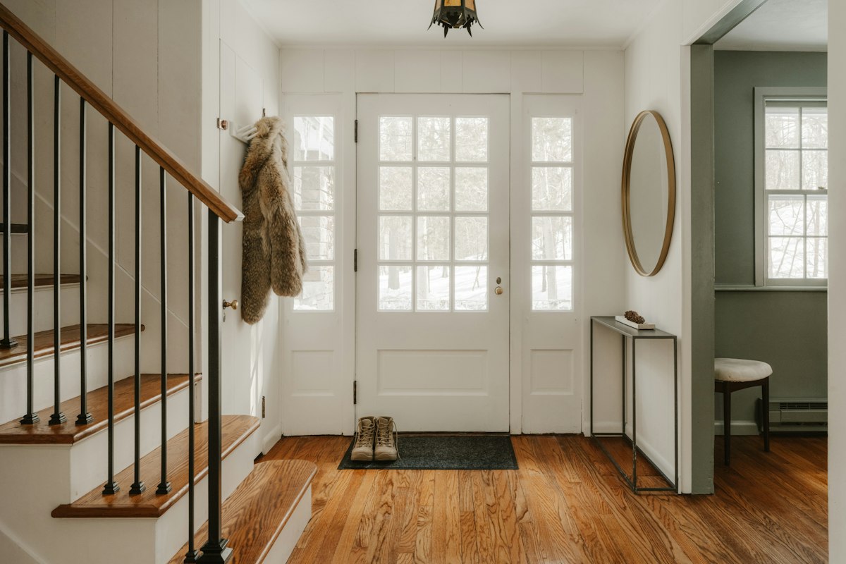 A bright entrance hall with a glazed front door and a doormat